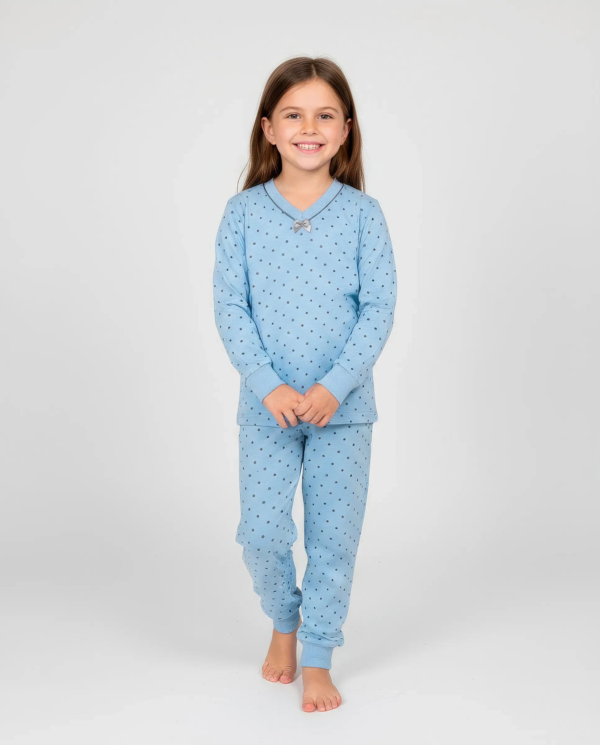 Niña viste confortable pijama largo de invierno estampado de pequeños topos grises, escote en pico con lacito