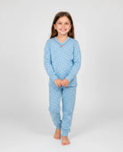 Niña viste confortable pijama largo de invierno estampado de pequeños topos grises, escote en pico con lacito