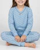 Detalle del confortable pijama de invierno para niña azul a topitos con cuello en pico y lazo decorativo