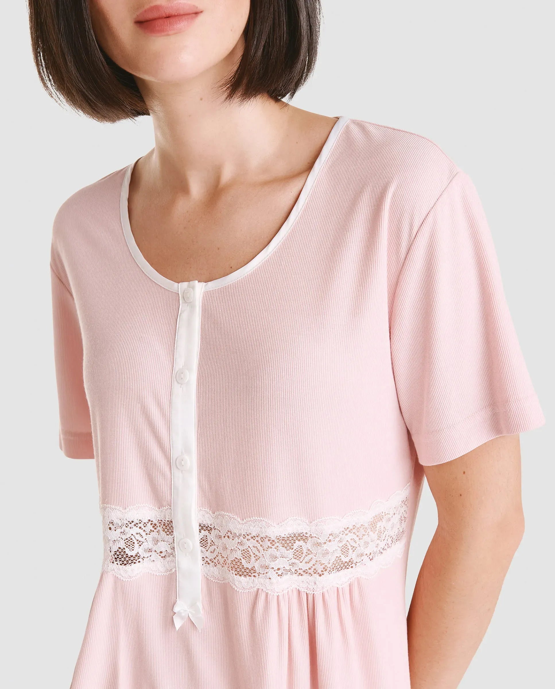 Vista detalle de chaquetilla de pijama lencero rosa de manga corta cuello redondo con pata, botones y puntilla en cintura