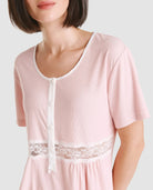 Vista detalle de chaquetilla de pijama lencero rosa de manga corta cuello redondo con pata, botones y puntilla en cintura