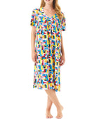Mujer luce vestido de verano de manga corta y colorido estampado geométrico