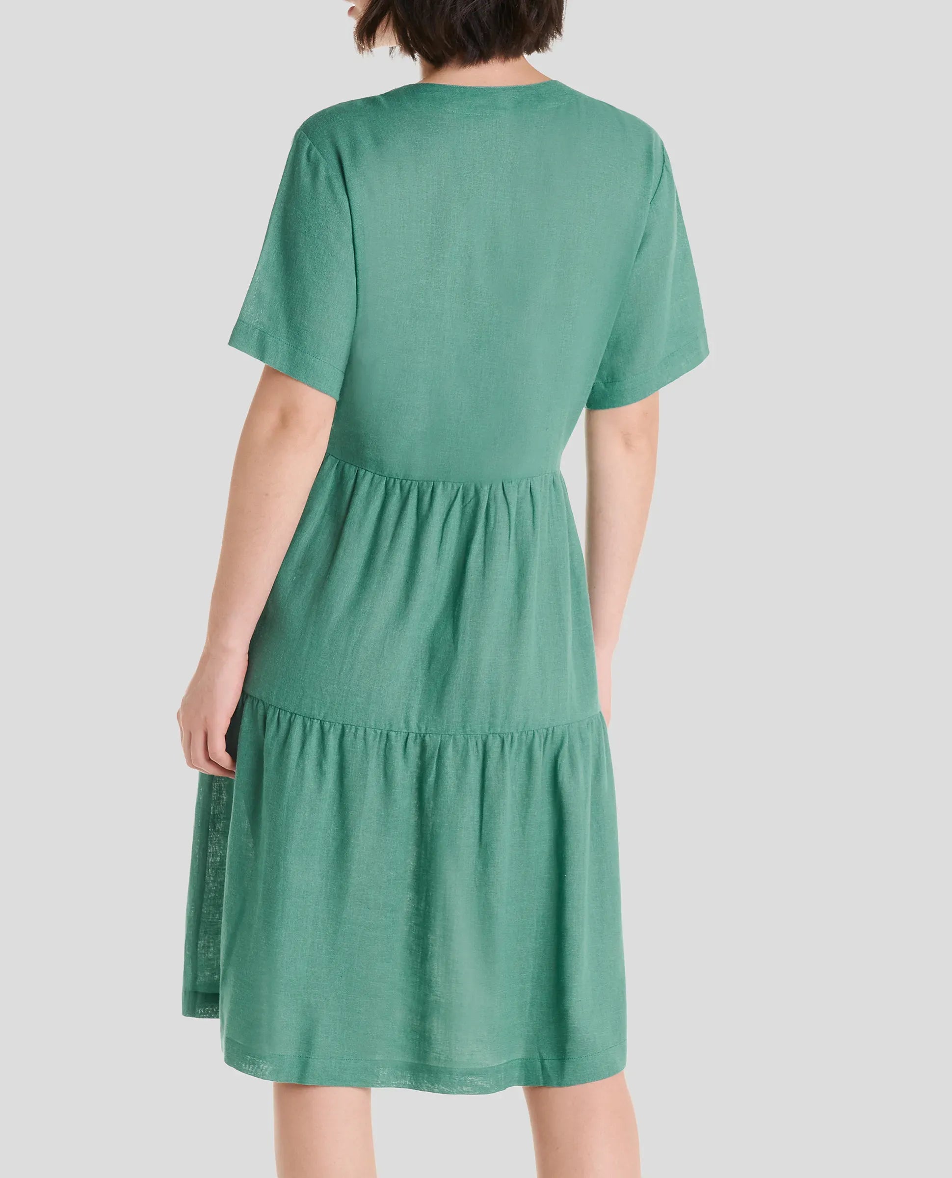 Vista trasera de vestido corto de verano de lino verde de manga corta