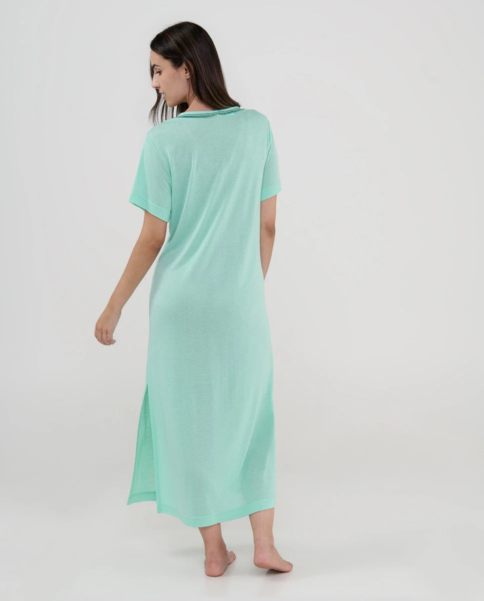 Mujer de espaldas con vestido playero largo verde menta y manga corta