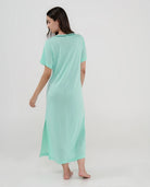 Mujer de espaldas con vestido playero largo verde menta y manga corta