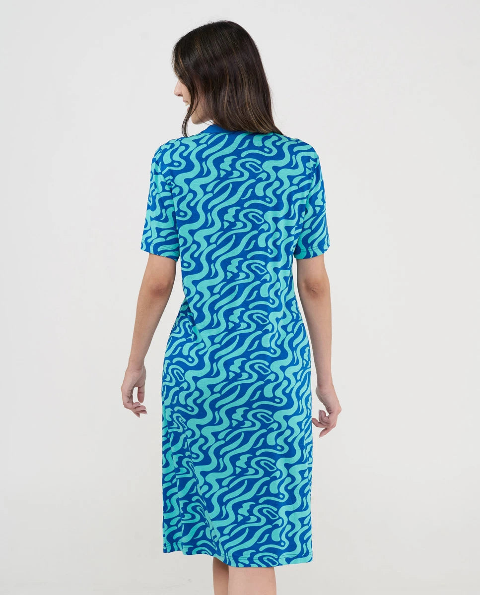 Vista de espaldas de mujer con vestido playero de manga corta azul estampado ondas