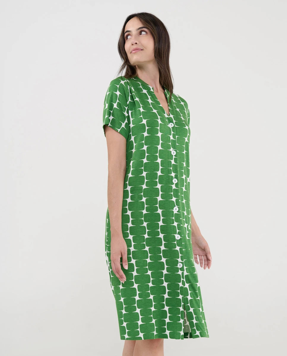 Mujer con vestido playero verde de manga corta abotonado y patrón geométrico blanco.