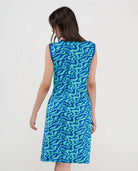 Modelo posa de espaldas con vestido playero corto sin mangas azul estampado ondas