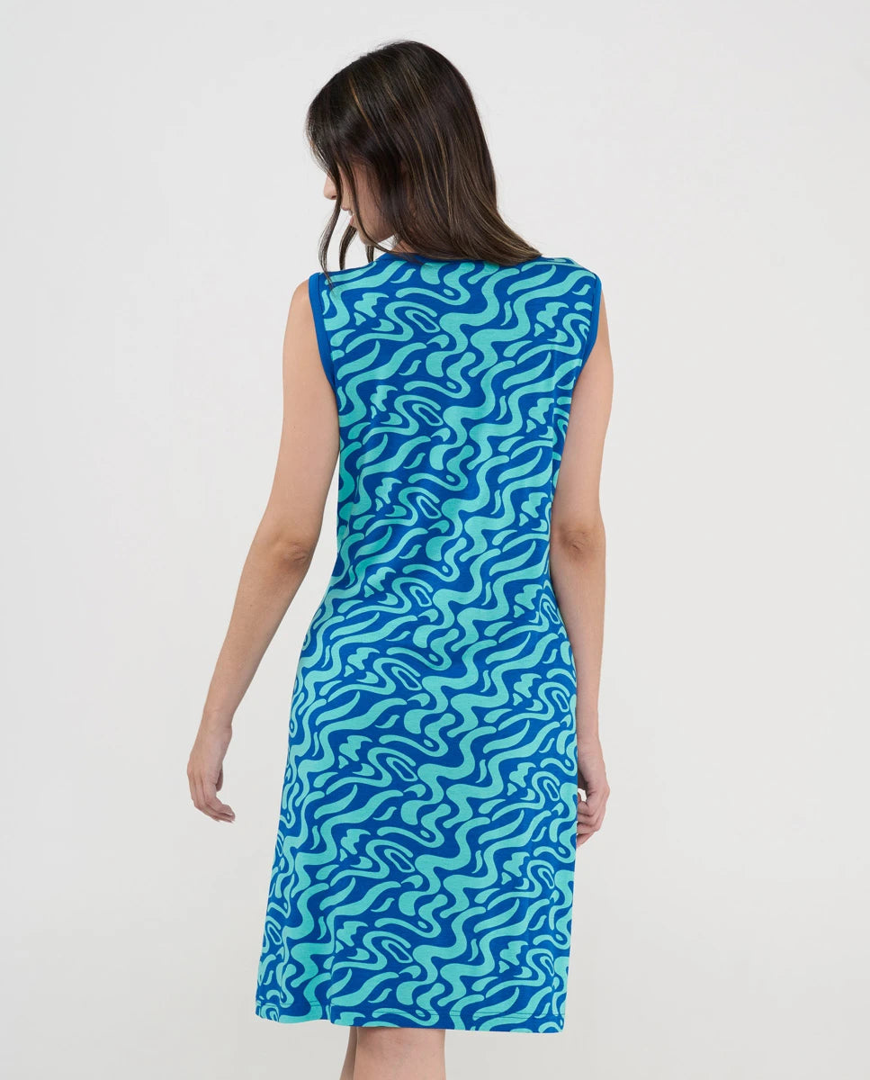 Modelo posa de espaldas con vestido playero corto sin mangas azul estampado ondas