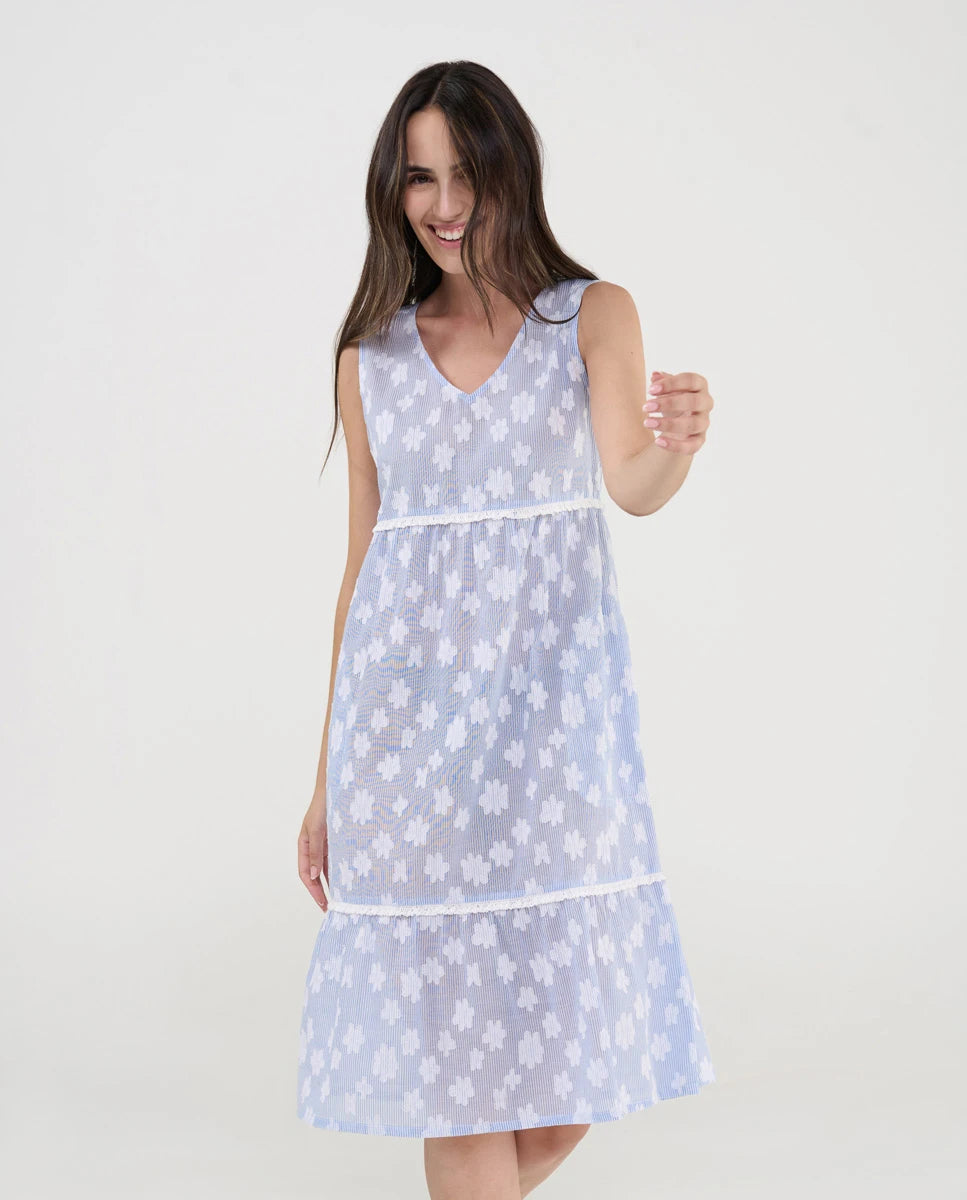 Mujer con vestido de playa corto sin mangas, cuello pico, dibujo flocado flores y puntilla, bolsillos laterales