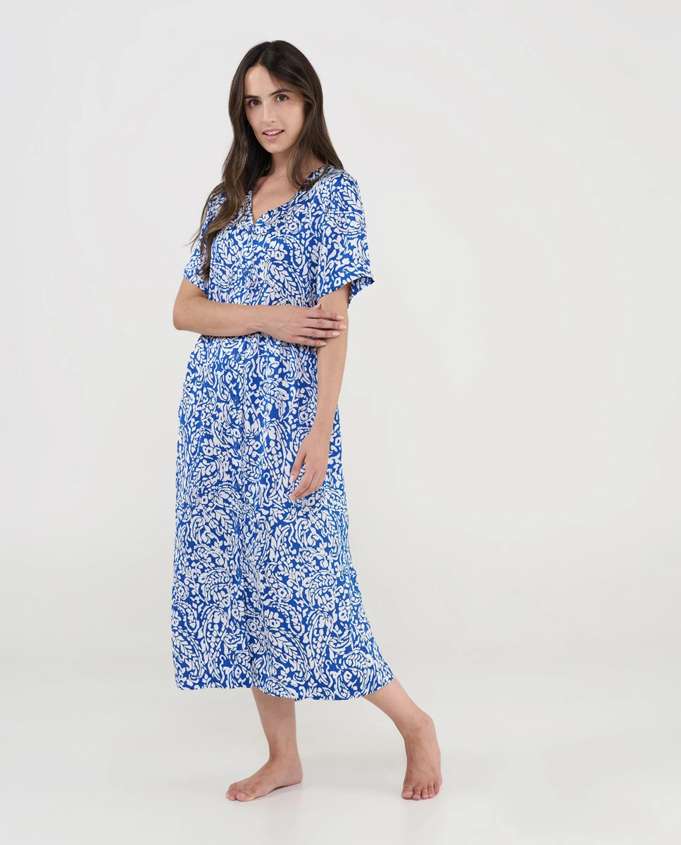 Mujer con vestido playero midi azul y blanco de estampado floral, manga corta y escote en V.