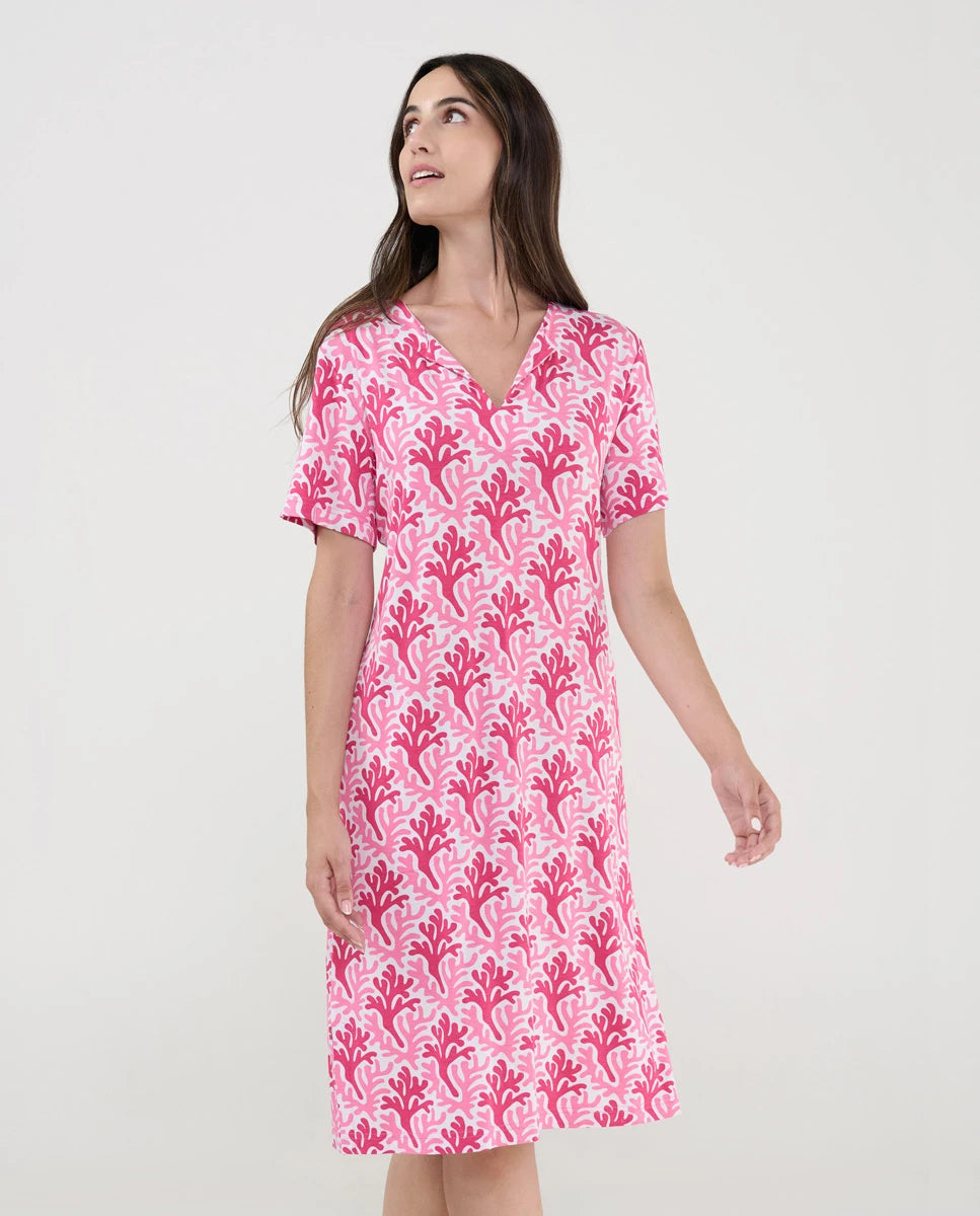 Mujer con vestido de baño corto de manga corta y estampado fucsia de corales