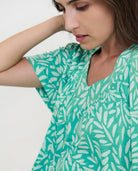 Detalle del escote en v del vestido playero color verde con estampado de hojas