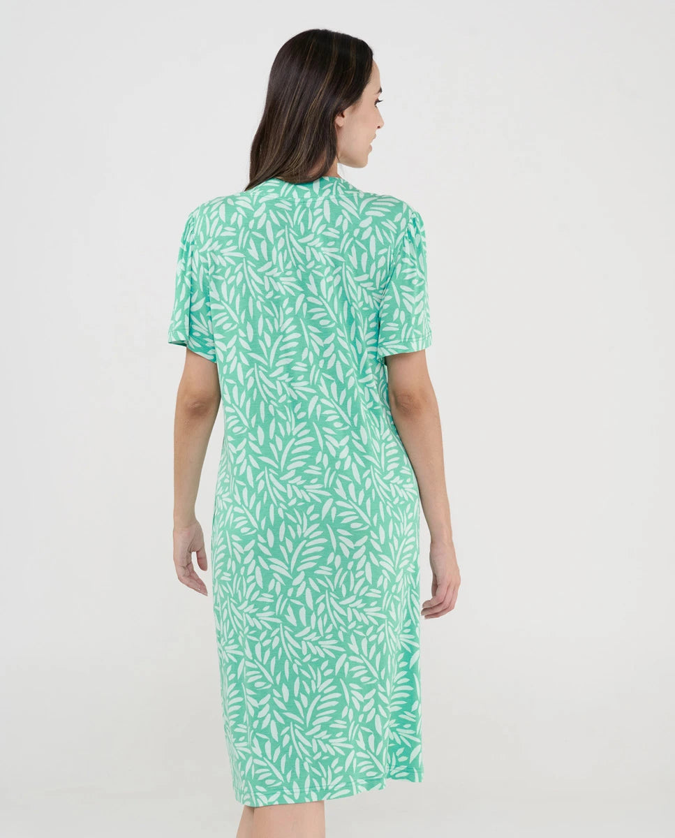 Mujer con vestido de verano corto verde con estampado de hojas vista de espaldas