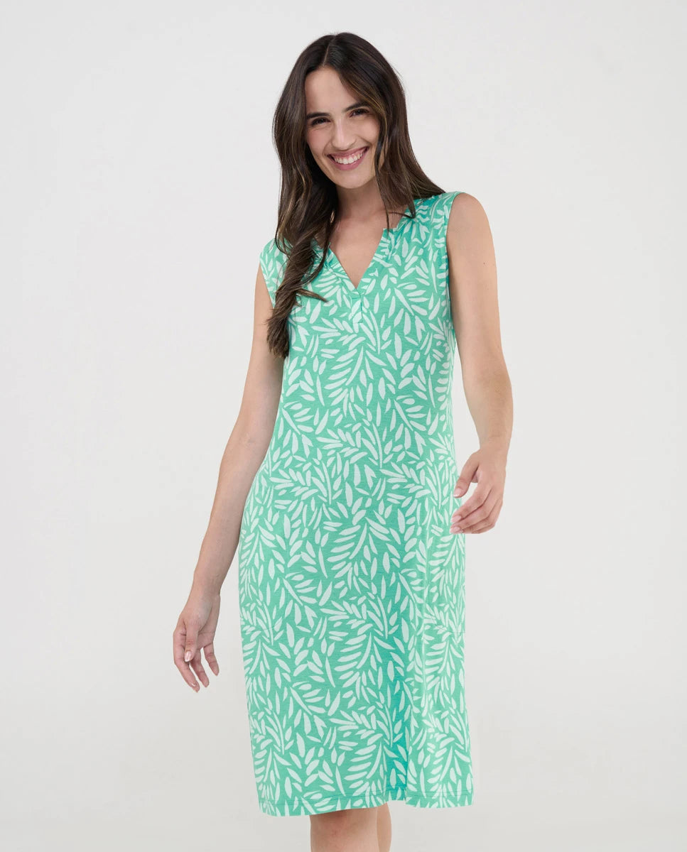Mujer luce vestido corto de playa sin mangas verde estampado hojas blancas